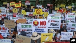 Anti-coup protesters display signs near the Indonesian Embassy in Yangon, Myanmar, Wednesday, Feb. 24, 2021. (AP Photo)