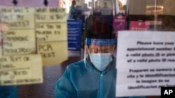 FILE - A test specialist works at a COVID-19 testing site in Los Angeles, Dec. 9, 2020. A lab in Minnesota confirmed Monday the first U.S. case associated with the variant originally seen in Brazil.