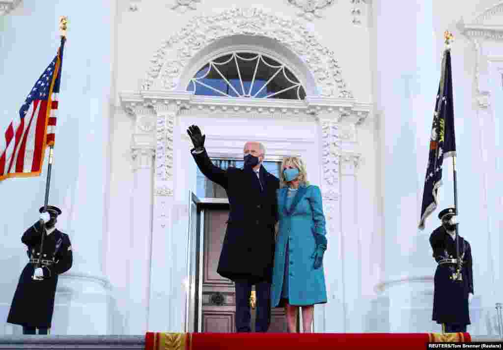 U.S. President Joe Biden waves through the window of a car during the Inauguration Day parade