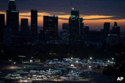 រូបឯកសារ៖ អ្នក​បើកបរ​រង់ចាំ​ចាក់​វ៉ាក់សាំង​បង្ការ​ជំងឺ​កូវីដ១៩ និង​ធ្វើ​តេស្ត​រក​ជំងឺ​នេះ​នៅ​ចំណត​រថយន្ដ​មួយ​កន្លែង​នៅ​ពហុកីឡដ្ឋាន Dodger Stadium ក្នុង​ទីក្រុង Los Angeles កាល​ពី​ថ្ងៃទី២៧ ខែមករា ឆ្នាំ២០២១។