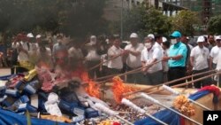 រូបឯកសារ៖ មន្ត្រីកម្ពុជាដុតគ្រឿងញៀន នៅភ្នំពេញ​ កាលពីថ្ងៃទី២៦ ខែមិថុនា​ ឆ្នាំ២០១៧។