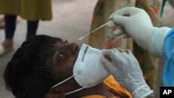 រូបឯកសារ៖ ក្មេងប្រុសម្នាក់កំពុងត្រូវបានមន្រ្តីសុខាភិបាលយកសំណាកទៅពិនិត្យរកជំងឺកូវីដ១៩ នៅមណ្ឌលសុខភាពមួយ ក្នុងក្រុង Hyderabad កាលពីថ្ងៃទី១៥ ខែកក្កដា ឆ្នាំ២០២០។