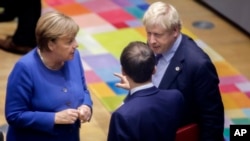 Kanselir Angela Merkel berbicara dengan PM Inggris Boris Johnson (kanan) dan Presiden Perancis Emmanuel Macron pada KTT Uni Eropa di Brussels, Belgia (foto: dok).