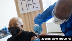 រូបឯកសារ៖ ស្ត្រី​ម្នាក់​ទទួល​វ៉ាក់សាំង​បង្ការ​ជំងឺ​កូវីដ១៩ របស់​ក្រុមហ៊ុន Pfizer-BioNTech នៅ​មន្ទីរពេទ្យ​មួយ​ក្នុង​ទីក្រុង​ញូវយ៉ក សហរដ្ឋ​អាមេរិក ថ្ងៃទី២៥ ខែកុម្ភៈ ឆ្នាំ២០២១។ 