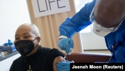 Debra Fraser-Howze menerima satu dosis vaksin COVID-19 buatan Pfizer-BioNtech di sebuah rumah sakit di Manhattan, New York, 25 Februari 2021. (Foto: Jeenah Moon/Reuters)