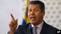 Henri Falcon, a former governor and former aide to the late President Hugo Chavez, speaks to the press after signing a document that states electoral guarantees for the upcoming presidential election at the National Electoral Council in Caracas, Venezuela