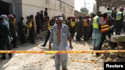 Seorang pria yang terluka menjauh saat saat para petugas membantu pencarian para korban serangan bom di Shuja Khanzada, provinsi Punjab, Atok, Pakistan, 16 Agustus 2015 (Foto: dok). 