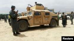 Des forces de sécurité afghans gardent le site de l'attentat suicide à l'ouest de Kaboul, Afghanistan, le 30 juin 2016. 