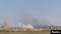 Smoke rises around the Syrian southern town of Bosra al-Sham, March 24, 2015. 