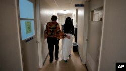 A 33-year-old mother of three from central Texas is escorted down the hall by clinic administrator Kathaleen Pittman prior to getting an abortion, Saturday, Oct. 9, 2021, at Hope Medical Group for Women in Shreveport, La.