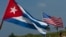 FILE - U.S. and Cuban flags fly. The countries re-established diplomatic relations earlier this year following a half century of estrangement.
