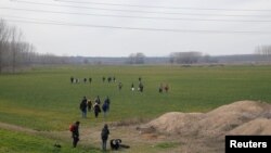 Sekelompok migA group of migrants walk through the Turkish-Greek border in a village near the border city of Edirne, Turkey, February 28, 2020. REUTERS/Huseyin Aldemir