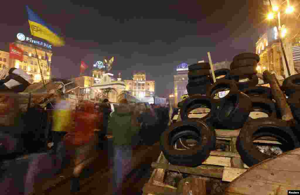Para demonstran pro-integrasi Eropa berjalan melewati barikade setelah protes di Lapangan Kemerdekaan di Kiev, 15 Desember 2013.