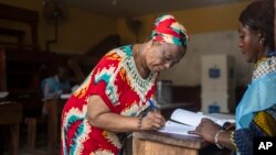 A voter prepares to cast her ballot in a polling station during the presidential elections in Kinshasa, Democratic Republic of Congo, Dec. 20, 2023.