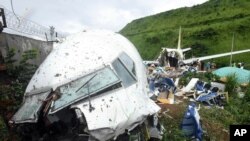 인도 케랄라주 인근 캘리컷 공항에서 추락 사고를 당한 항공기 잔해 근처에 8일 사람들이 서 있다. 