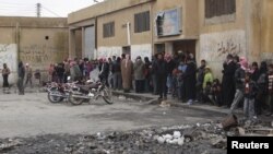 People queue to buy bread at a local bakery at Tel Abyed near Hasaka, December 17, 2012. 