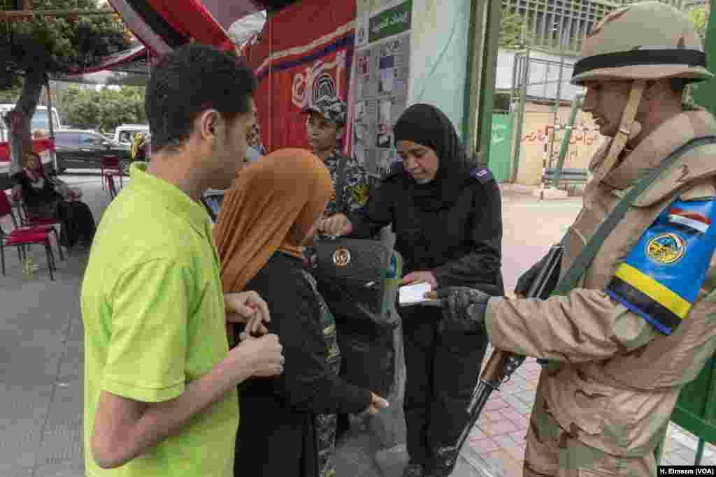 A member of the police inspects an Egyptian voter in Cairo, March 28, 2018. Security was tight amid reports of terrorist threats. Some Egyptians blamed the threat — and tough security measures — for the low turnout in parts of the Egyptian capital.