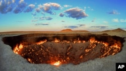 The crater fire named "Gates of Hell" is seen near Darvaza, Turkmenistan, Saturday, July 11, 2020. The president of Turkmenistan is calling for an end to one of the country's blazing desert natural gas crater. (AP Photo/Alexander Vershinin)