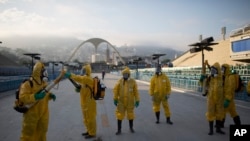 Des agents de santé se préparent pour pulvériser l'insecticide contre le moustique Aedes aegypti qui transmet le virus Zika, sous les gradins du Sambadrome de Rio de Janeiro, au Brésil, le 26 janvier 2016. (AP Photo/Leo Correa) 