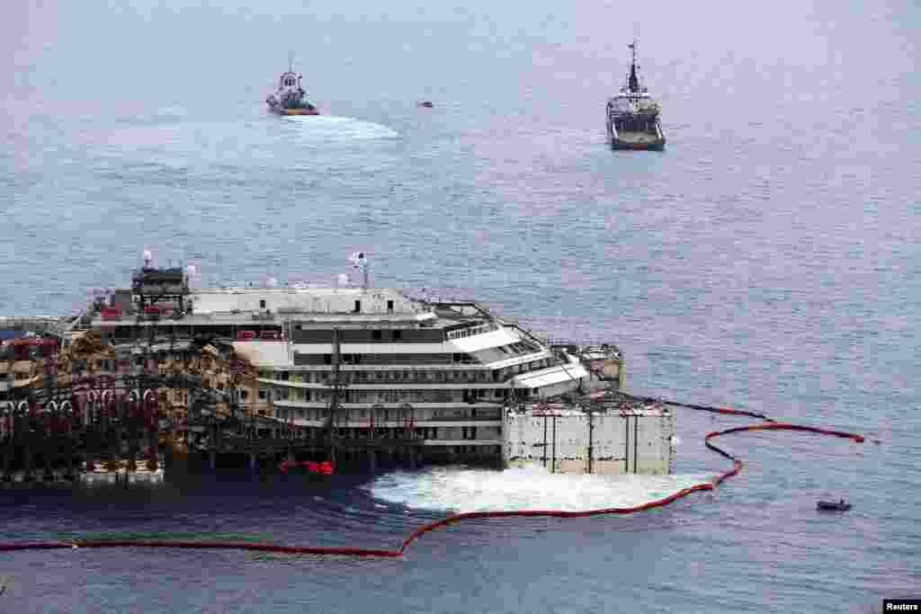 Kapal pesiar Costa Concordia yang tenggelam diangkat di pelabuhan Pulau Giglio, Italia.