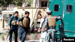 Afghan policemen transport the body of a police after gunmen attack in Jalalabad city eastern Afghanistan, May 17, 2017. 
