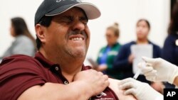 Cesar Gonzalez reacts to getting an influenza vaccine shot at Eastfield College in Mesquite, Texas, Thursday, Jan. 23, 2020. 