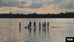 Cambodians bathe in the Mekong River while waiting for the sun to set in Stung Treng province, Cambodia, July 16, 2020. (Sun Narin/VOA Khmer) 