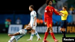 Argentina's players celebrate near Belgium's Marouane Fellaini, left, after winning their 2014 World Cup quarter-finals, Brasilia national stadium, July 5, 2014.