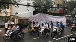 FILE - A tarpaulin covers the damaged facade of a police station in Ho Chin Minh city on June 20, 2018 following an explosion.