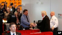 លោក​ ដូណាល់​ ត្រាំ ចាប់​ដៃ​ជា​មួយ​សន្តិសុខ​ ខណៈ​លោក​ចេញពី​អាគារ​កាសែត ញូវយ៉កថាម កាល​ពីថ្ងៃ​ទី​២២ ខែ​វិច្ឆិកា។