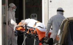 FILE - A patient is carried on a stretcher from a nursing home to a hospital, as the spread of the coronavirus disease (COVID-19) continues, in Rome, Italy, May 2, 2020.