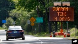In this Wednesday, June 10, 2020, photo, a sign in Gilead, Maine, near the border with New Hampshire, warns visitors entering Maine that they are required to quarantine for 14 days. Residents of New Hampshire and Vermont are exempt. (AP Photo/Robert F. Bu