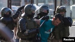 Belarusian law enforcement officers detain a man during a rally following the presidential election in Minsk, Aug. 11, 2020.