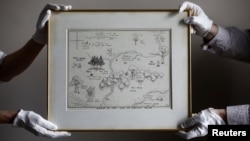 FILE - Sotheby's staff hold the original map of Winnie the Pooh's Hundred Acre Wood by E.H. Shepard at Sotheby's auction rooms in London, Britain, May 31, 2018.