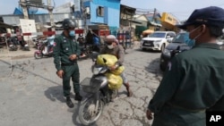 រូបឯកសារ៖ អាជីវករម្នាក់ដែលកំពុងដឹកសាច់មាន់ទៅកាន់ផ្សារ ត្រូវបានអាជ្ញាធរអនុញ្ញាតឲ្យធ្វើដំណើរឆ្លងកាត់នៅតំបន់បិទច្រកចេញចូលមួយកន្លែង នៅក្បែរអាកាសយានដ្ឋានអន្តរជាតិភ្នំពេញ ខណៈភ្នំពេញកំពុងរងការឆ្លងរាលដាលនៃជំងឺកូវីដ១៩ ធ្ងន់ធ្ងរ កាលពីថ្ងៃទី ១៥ ខែមេសា ឆ្នាំ ២០២១។