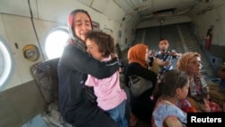 Seorang perempuan memeluk searing anak di helikopter militer setelah dievakuasi oleh pasukan Irak dari Amerli, Baghdad utara, 29 Agustus 2014.