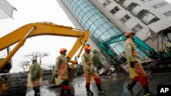 Rescuers work on a search operation at an apartment building that collapsed after a strong earthquake in Hualien County, eastern Taiwan, Feb. 7, 2018. A magnitude 6.4 earthquake struck late Tuesday night caused several buildings to cave in and tilt dangerously. 