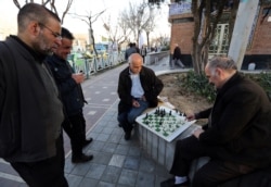 FILE - Iranian men play chess in a street in Tehran, Feb. 23, 2016.