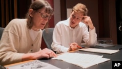 Professor Patricia Hall and graduate student Joshua Devries review the music manuscript for "The Most Beautiful Time of Life" at the Duderstadt Center recording studio on campus in Ann Arbor, Mich. (Christopher Boyes/University of Michigan via AP)