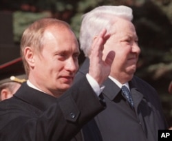Presiden Rusia Vladimir Putin, kiri, melambai saat ia berdiri bersama mantan Presiden Boris Yeltsin dalam parade di Lapangan Merah, di Moskow, 9 Mei 2000. (Foto: AP)