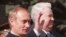 FILE - Russian President Vladimir Putin, left, waves as he stands with former President Boris Yeltsin during a parade on Red Square, in Moscow, May 9, 2000. 