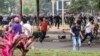 People run as riot police officers (back) try to disperse protesters against a chemical plant project in Maoming, Guangdong province, March 31, 2014.
