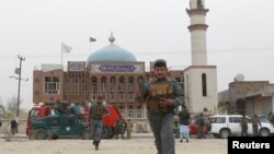 Afghan policemen patrol in front of the Baqir ul Olum mosque on Nov. 21, 2016. Dozens were killed and injured after a suicide bomb attack. 