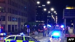 រូបថត​ដោយ​ទូរស័ព្ទ​ដៃមួយ​បង្ហាញ​ពី​រថយន្ត​ប៉ូលិស​អង់គ្លេស​បិទ​ច្រក​ចូល​ស្ពាន​ទីក្រុង​ឡុងដ៍ នៅ​កណ្តាល​ទីក្រុង​ឡុងដ៏​ នៅ​ថ្ងៃ​ទី៣ ខែ​មិថុនា ឆ្នាំ២០១៧ ក្រោយ​មាន​ឧបទ្ទវហេតុ​នៅ​លើ​ស្ពាន​នោះ។ សាក្សី​បាន​ថ្លែង​ថា​ ពួក​គេ​បាន​ឃើញ​រថយន្ត​នោះ​បុក​ក្រុម​អ្នក​ថ្មើរ​ជើង។ (រូបថត៖ AFP/Daniel Sorabji)
