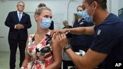 Australian Prime Minister Scott Morrison, left, watches as Sarah Fletcher receiving a vaccine at the Sydney local health district vaccination hub in Sydney, Feb. 19, 2021.
