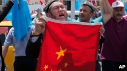 Uighurs living in Turkey and Turkish supporters, chant slogans before burning a Chinese flag, July 5, 2015. 