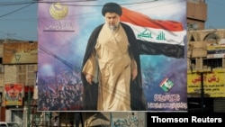 Sebuah poster ulama Syiah Irak Moqtada al-Sadr di distrik Kota Sadr Baghdad. (Foto: Reuters)