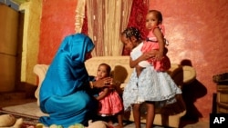 Youssria Awad plays with her daughters in their home, in Khartoum, Sudan, June 14, 2020. She refused to carry out female genital mutilation on them.