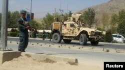 Seorang polisi Afghanistan berjaga-jaga di lokasi ledakan bom mobil di Kabul, Afghanistan, 24 September 2017.