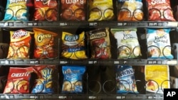 This Sept. 7, 2019 photo shows items in a vending machine in New York. Americans are addicted to snacks, and food experts are paying closer attention to what that might mean for health and obesity.